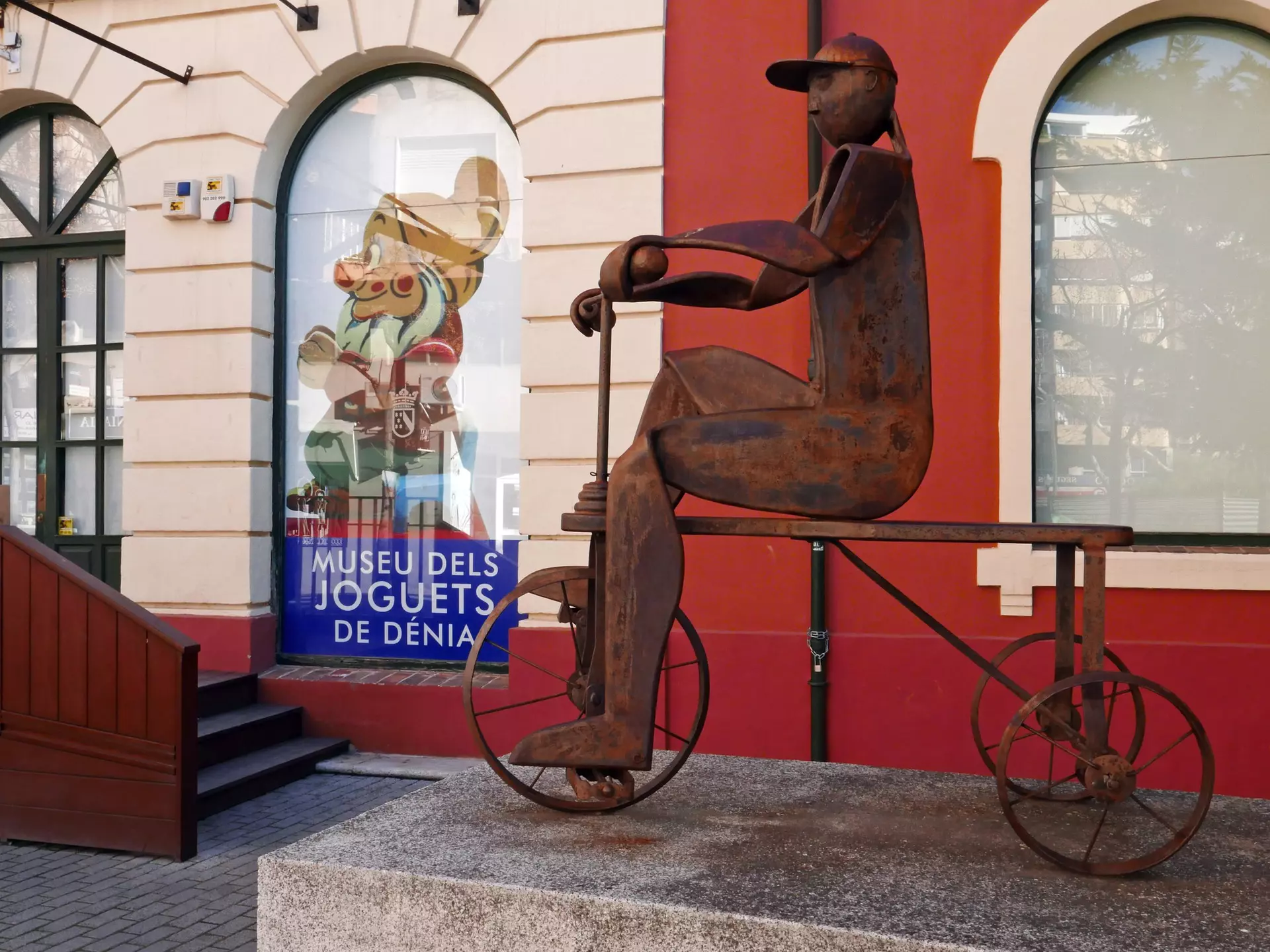 DENIA, SPAIN – JANUARY 28 2019:The exterior of the toy museum 'Museo del Juguete' in the old train station of Denia. With a sculpture of corten steel that depicts a child on a tricycle , License Type: media, Download Time: 2025-10-16T23:15:19.000Z, User: LP_YKhanna, Editorial: true, purchase_order: 65050 - Digital Destinations and Articles, job: Lonely Planet, client: App Content, other: Yuvraj Khanna