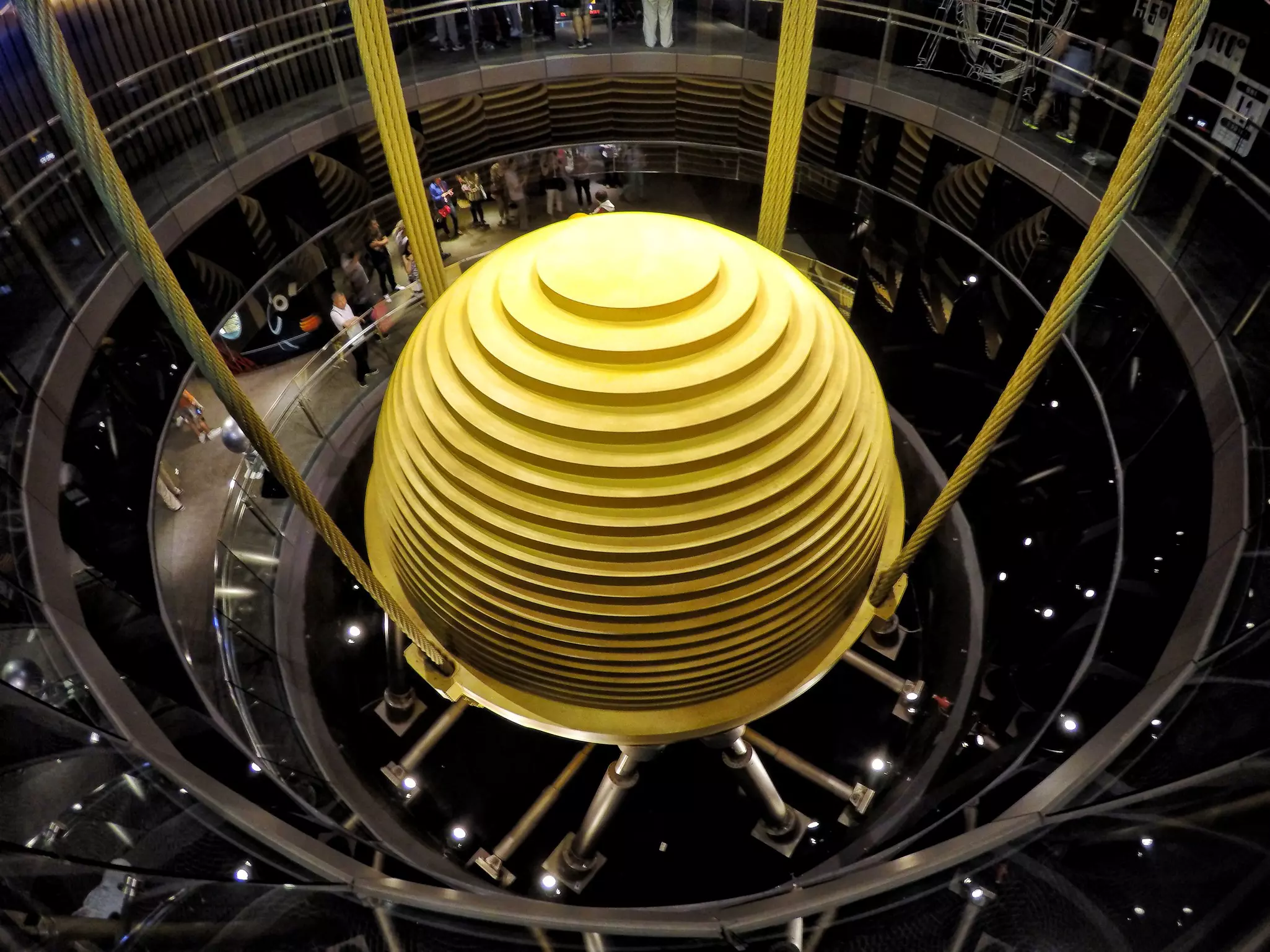 Tourists observe the world's largest tuned mass damper in Taipei 101.