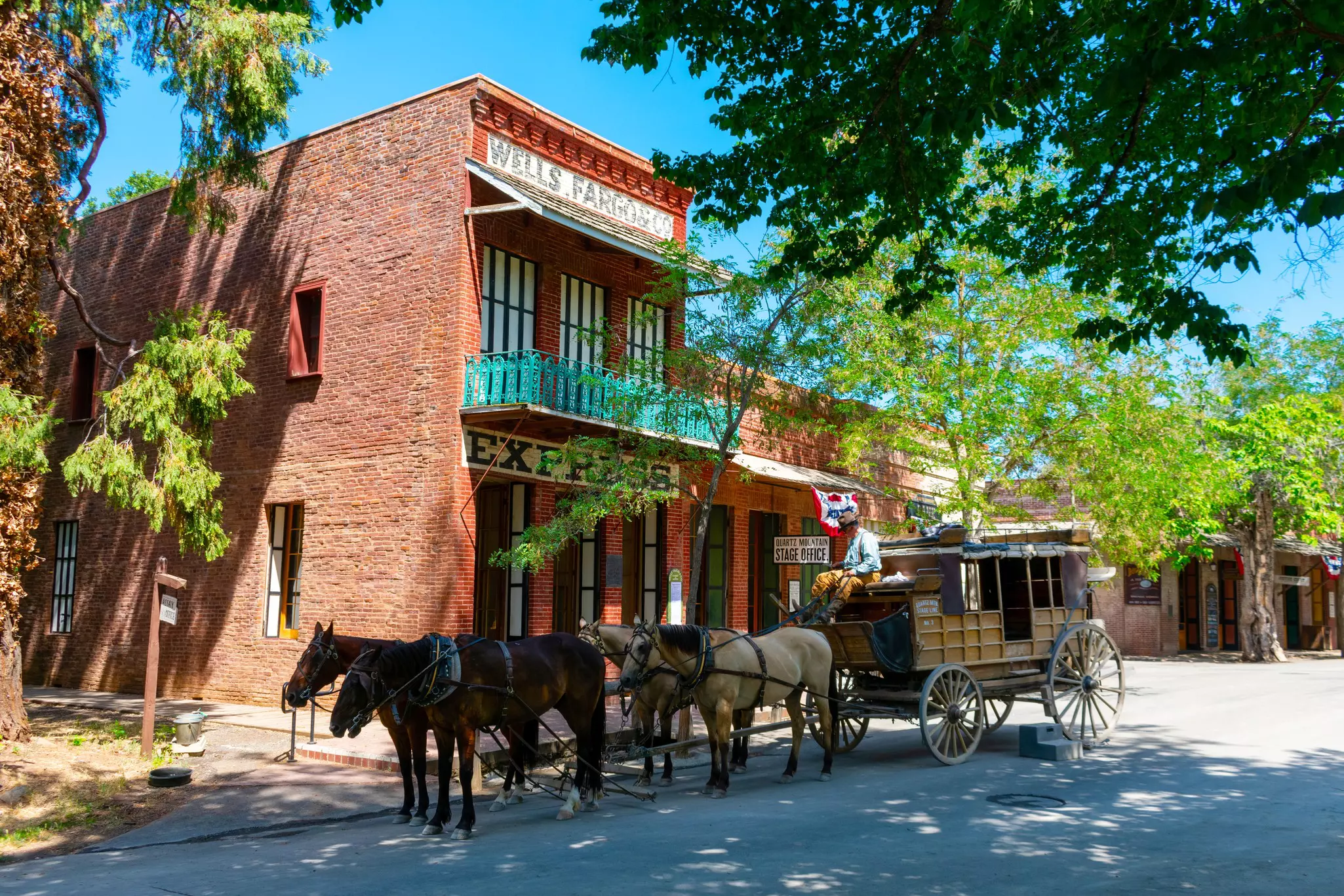 A horse-drawn stagecoach ride waits for passengers near preserved historic building in Columbia State Historic Park, in Gold Country © Michael Vi / Shutterstock
