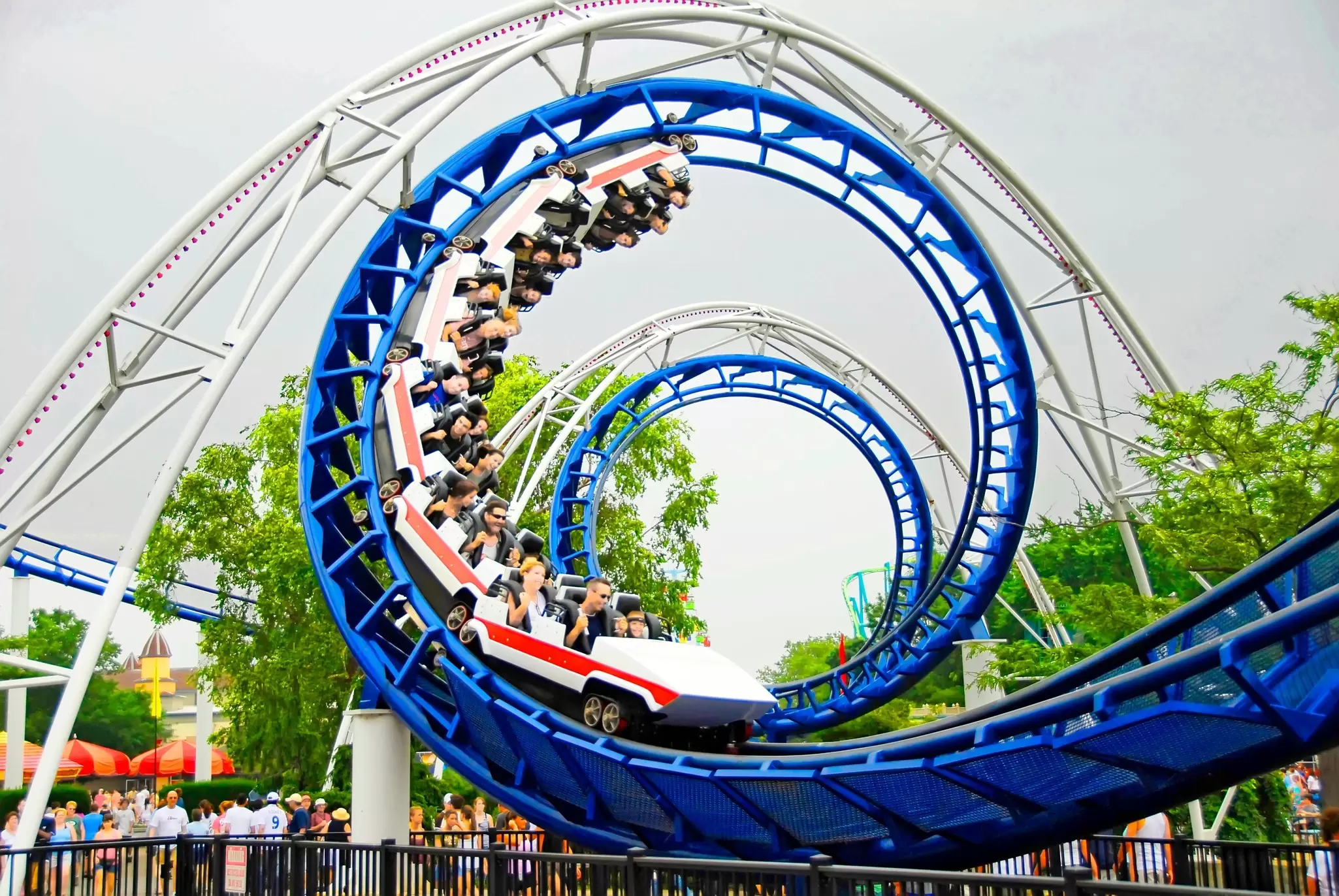 A blue roller-coaster track with passengers corkscrewing around at Cedar Point Amusement Park in Sandusky, Ohio