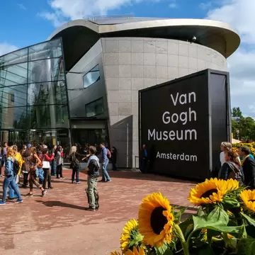 Amsterdam, the Netherlands, September 5, 2015: crowd in front of the new wing of the Van Gogh Museum with sunflowers in the foreground  License Type: media  Download Time: 2021-09-21T18:01:56.000Z  User: Norma.PrauseBrewer_LonelyPlanet  Is Editorial: Yes  purchase_order:   