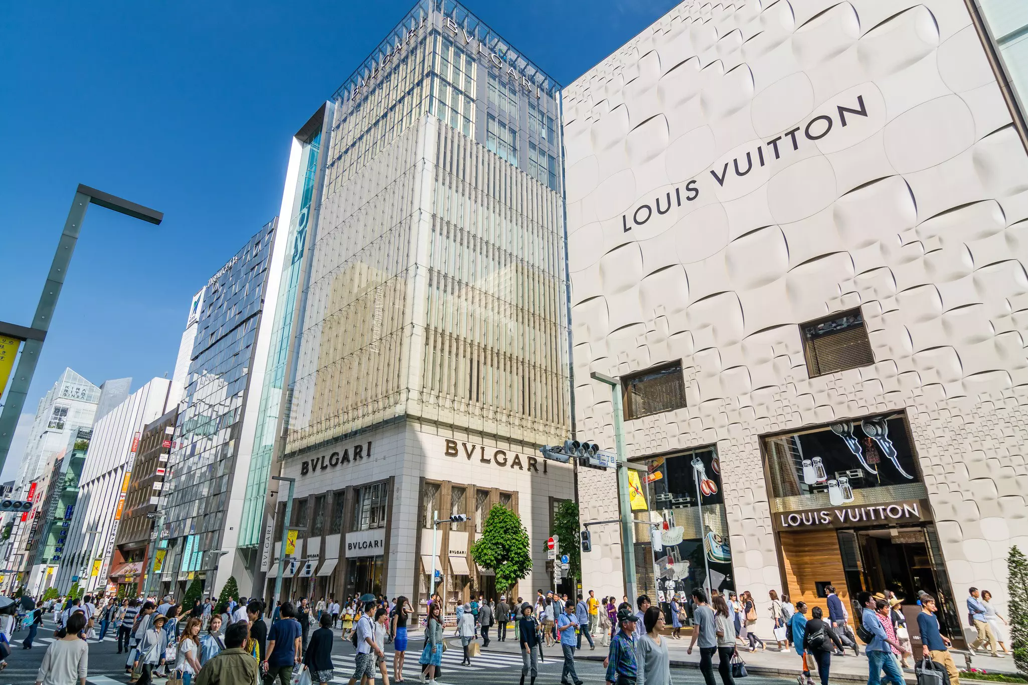 Crowds shopping in the luxury fashion district that has been closed to traffic and become a large pedestrian zone.