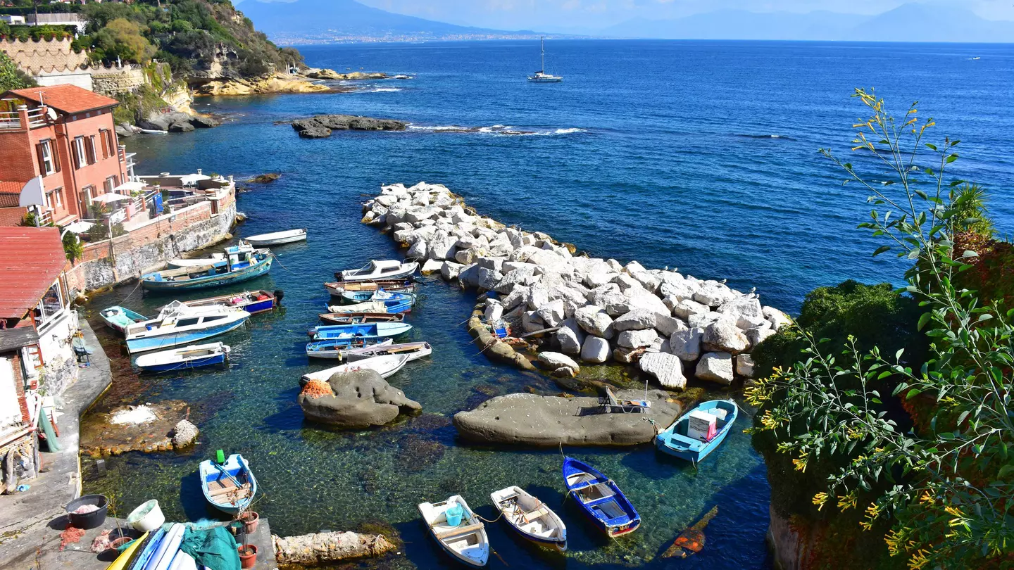 Boats docked at the small port of Marechiaro with Vesuvius in the background.