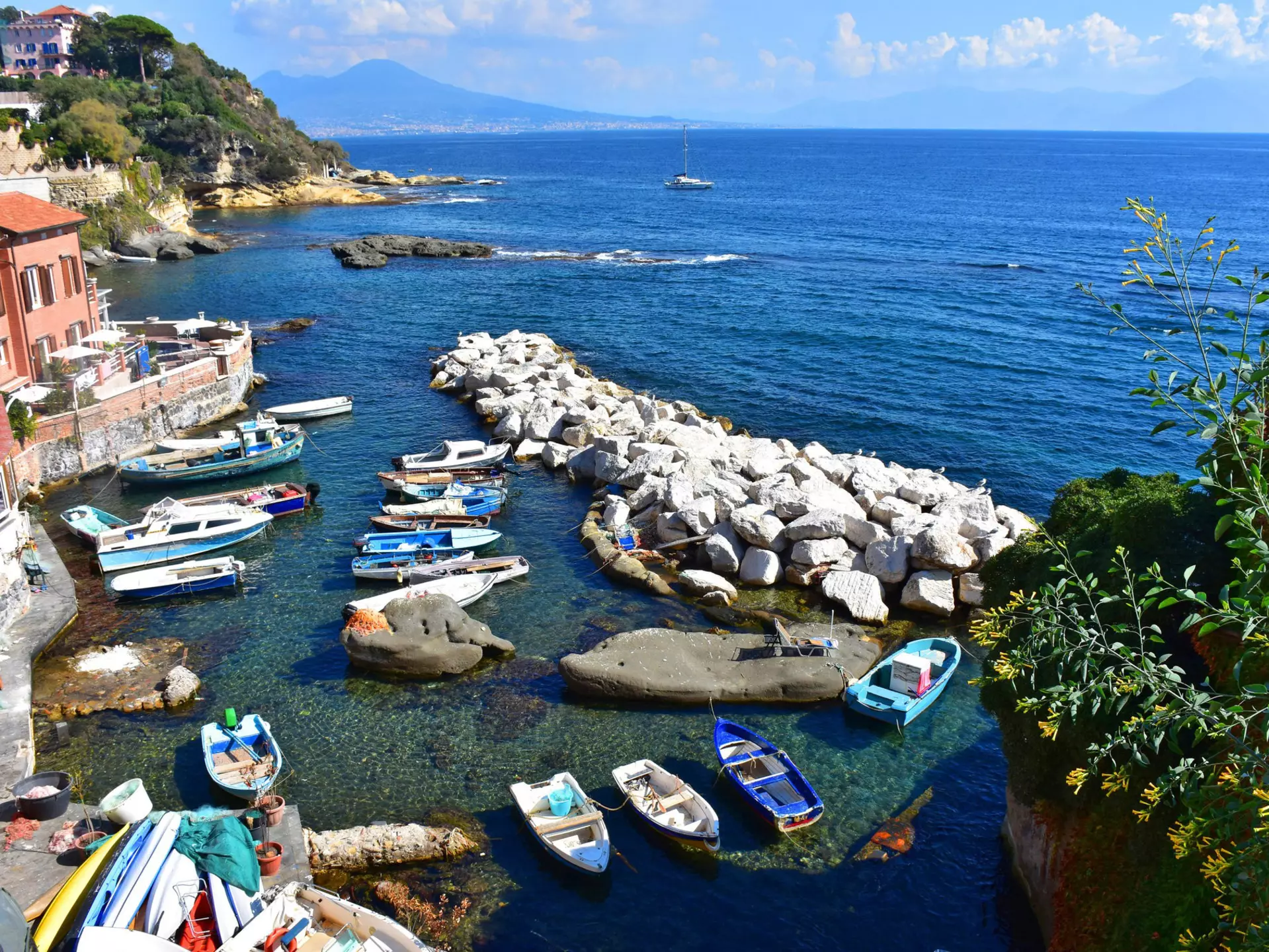 Boats docked at the small port of Marechiaro with Vesuvius in the background.