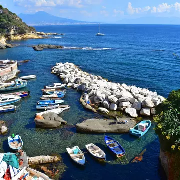 Boats docked at the small port of Marechiaro with Vesuvius in the background.