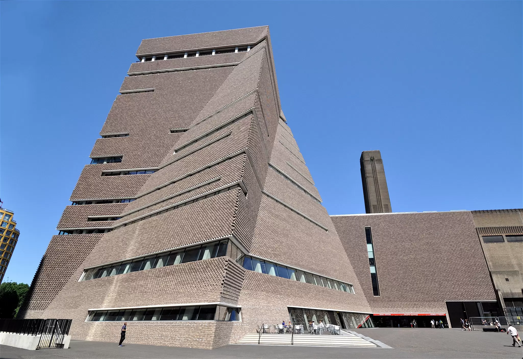 Exterior shot of a large brick building with a angular sections and an unusual brick arrangement