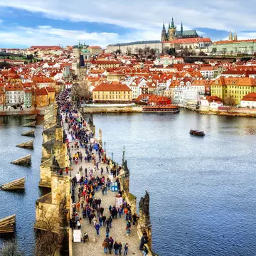 Panorama of Prague with the Castle, Charles Bridge, Vltava river and red roofs of the old town, Czech Republic.