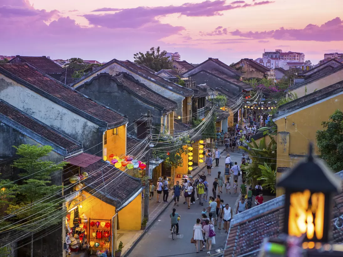 People walk down the colonial streets in historic old town Hoi An.