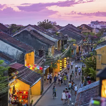 People walk down the colonial streets in historic old town Hoi An.
