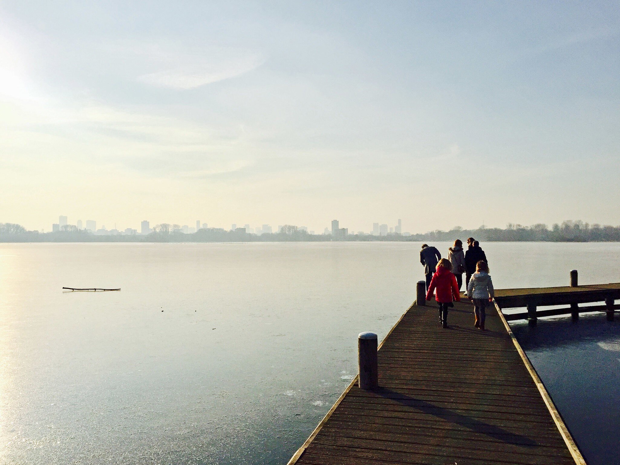 A family walks along the pier by the lake at Kralingse Bos in Rotterdam.