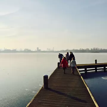A family walks along the pier by the lake at Kralingse Bos in Rotterdam.