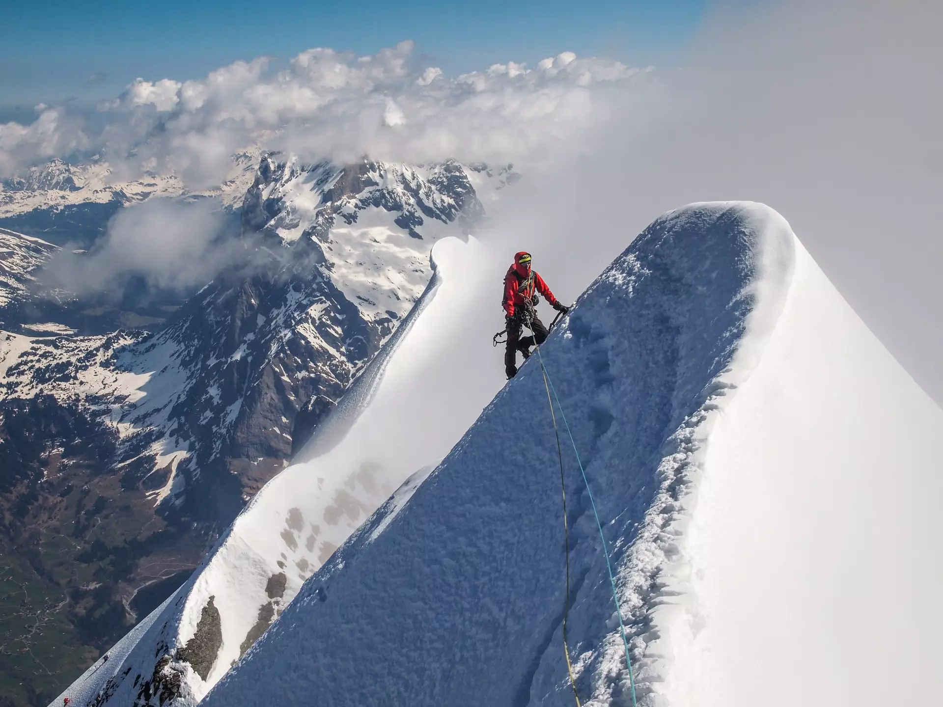 Climber on the top of Eiger. Exposed steep snow ridge. Above the clouds., License Type: media, Download Time: 2025-12-03T18:59:06.000Z, User: fabricencoredesign31, Editorial: false, purchase_order: 56530 - Guidebooks, job: Global Publishing-WIP, client: Experience Switzerland 1, other: Fabrice Robin