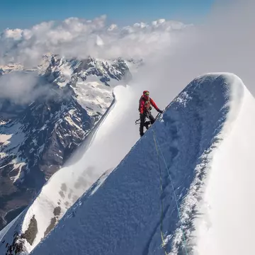 Climber on the top of Eiger. Exposed steep snow ridge. Above the clouds., License Type: media, Download Time: 2025-12-03T18:59:06.000Z, User: fabricencoredesign31, Editorial: false, purchase_order: 56530 - Guidebooks, job: Global Publishing-WIP, client: Experience Switzerland 1, other: Fabrice Robin