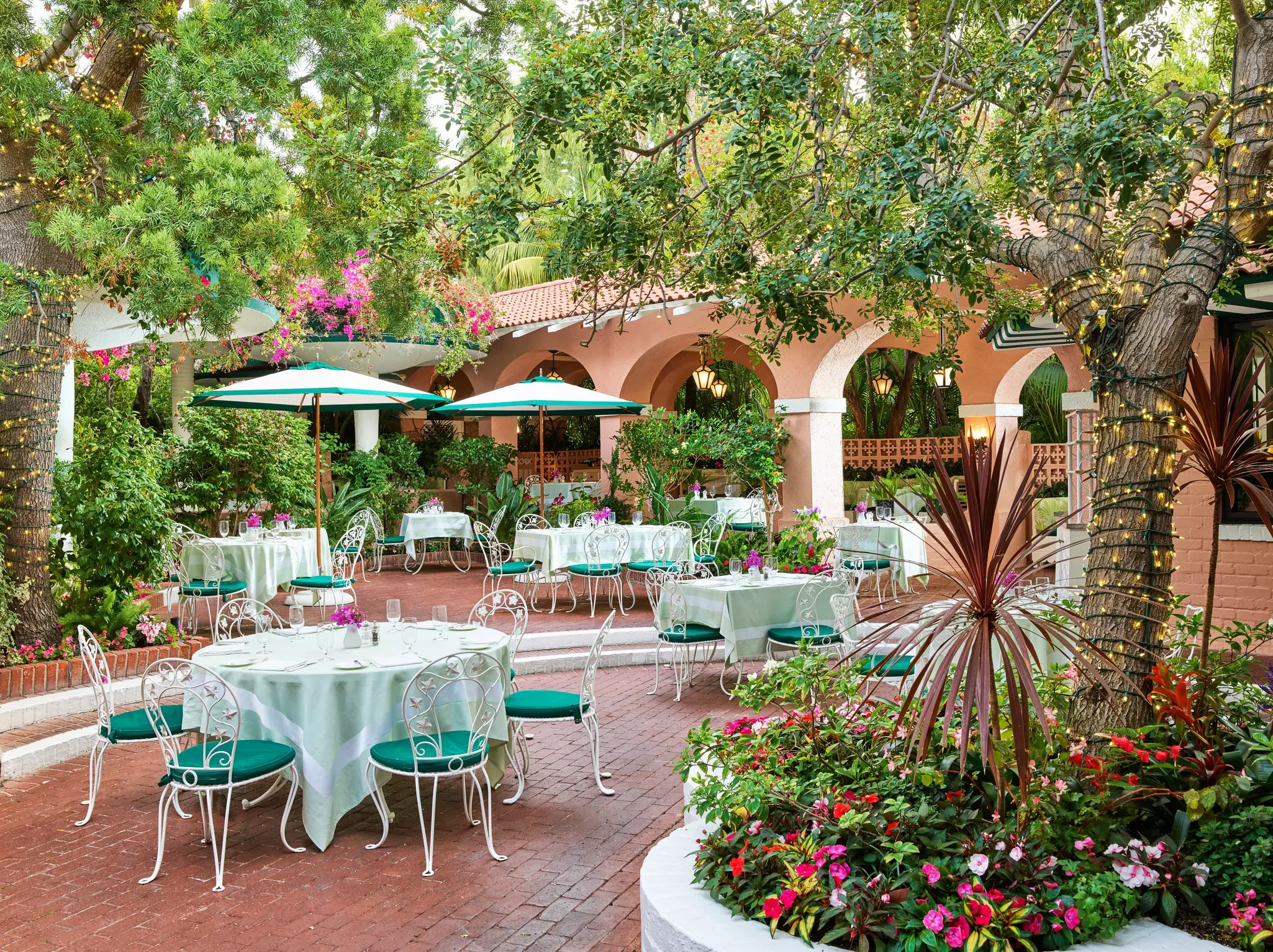 A pink patio with a group of tables and chairs.
