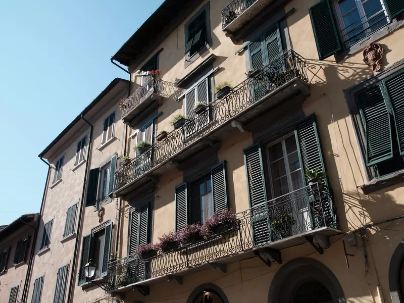 Apartments in a city with wrought-iron balconies and shuttered windows.