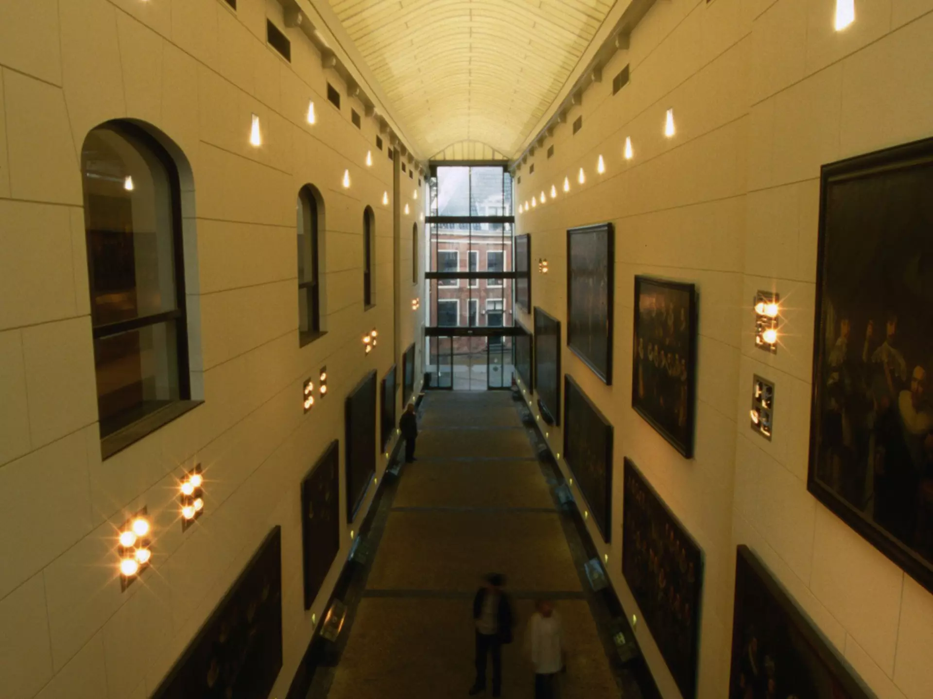 A shot downwards of a long hallway lined with paintings