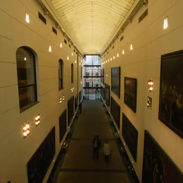 A shot downwards of a long hallway lined with paintings