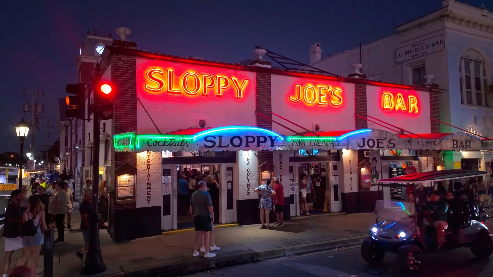A neon sign illuminates Sloppy Joe’s restaurant at night on Duval St, Key West