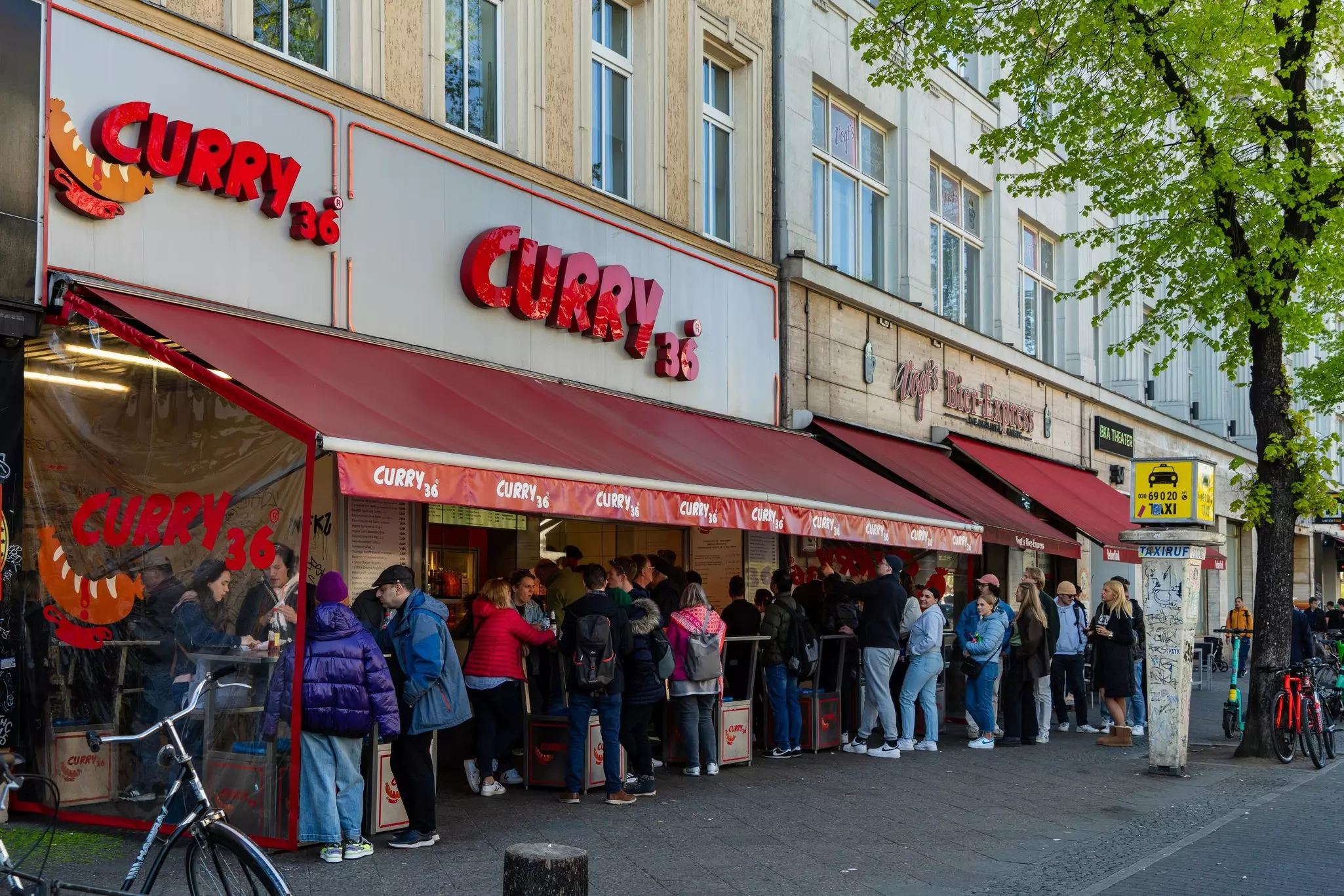 A line of people outside a fast-food restaurant called Curry 36