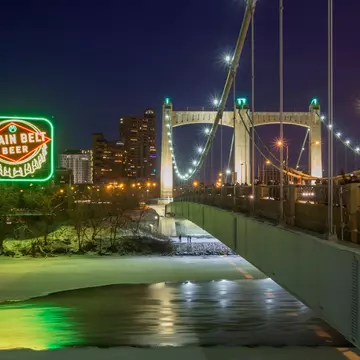 MINNEAPOLIS, MN - DECEMBER 2017 - A Long Exposure Night Shot of the Inaugural Relighting of the Iconic Grain Belt Beer Sign along the Frozen Mississippi River by the Hennepin Avenue Bridge in Winter  License Type: media  Download Time: 2021-08-05T14:31:47.000Z  User: AMccarthy_lonelyplanet  Is Editorial: Yes  purchase_order:   