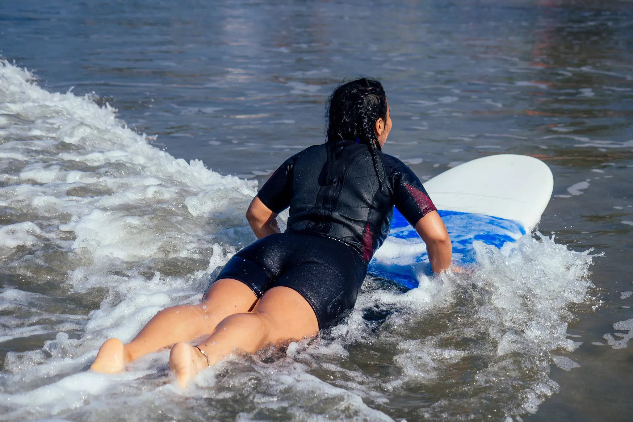 A trainee surfer learning to surf in Goa, India.