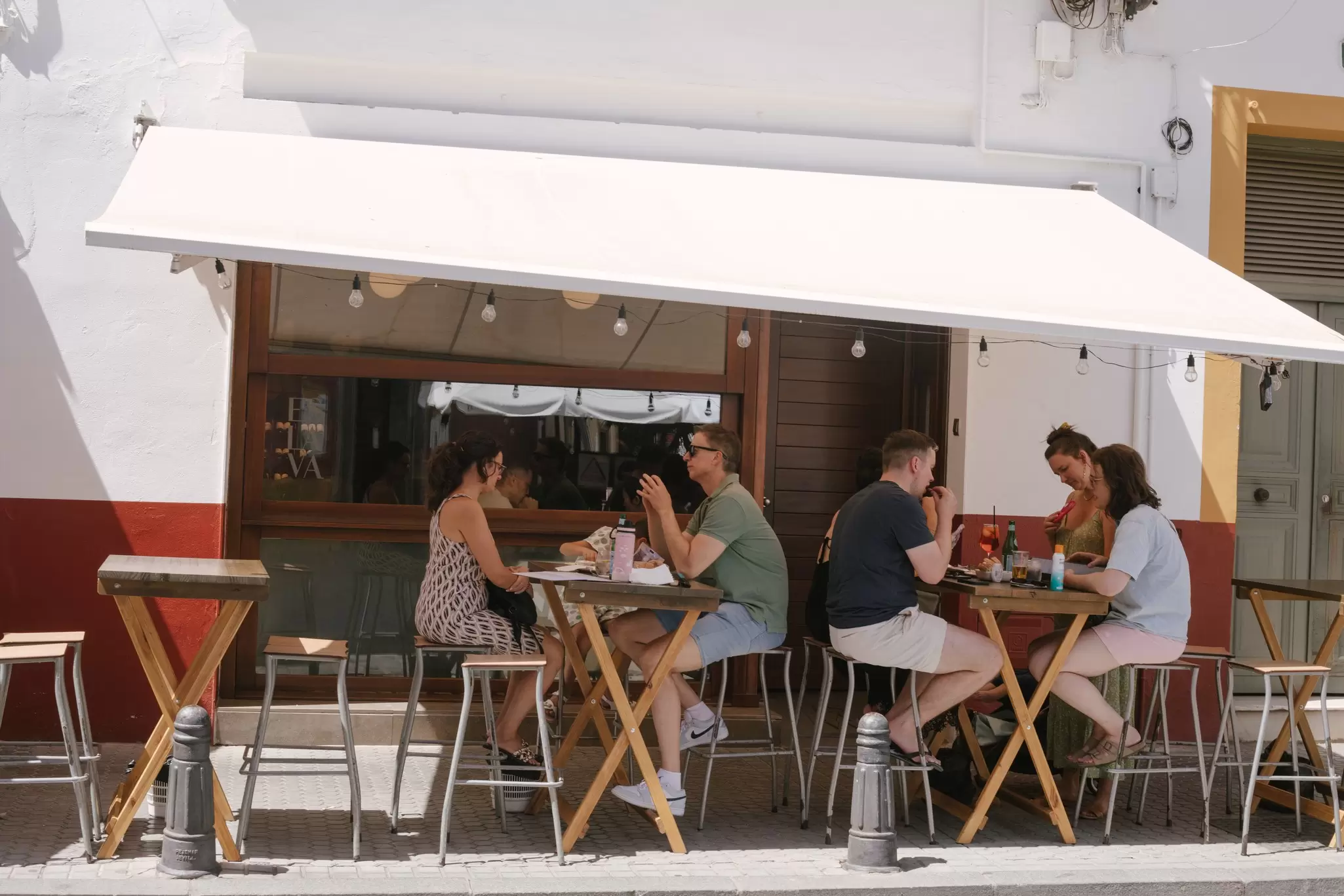 People eating tapas on a terrace at a restaurant in Seville, Spain.