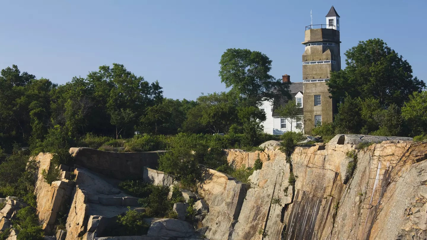 A WW2 submarine lookout tower and an old granite quarry above a body of water at Halibut Point State Park in Massachusetts.