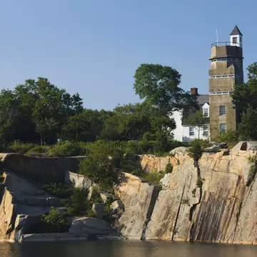 A WW2 submarine lookout tower and an old granite quarry above a body of water at Halibut Point State Park in Massachusetts.