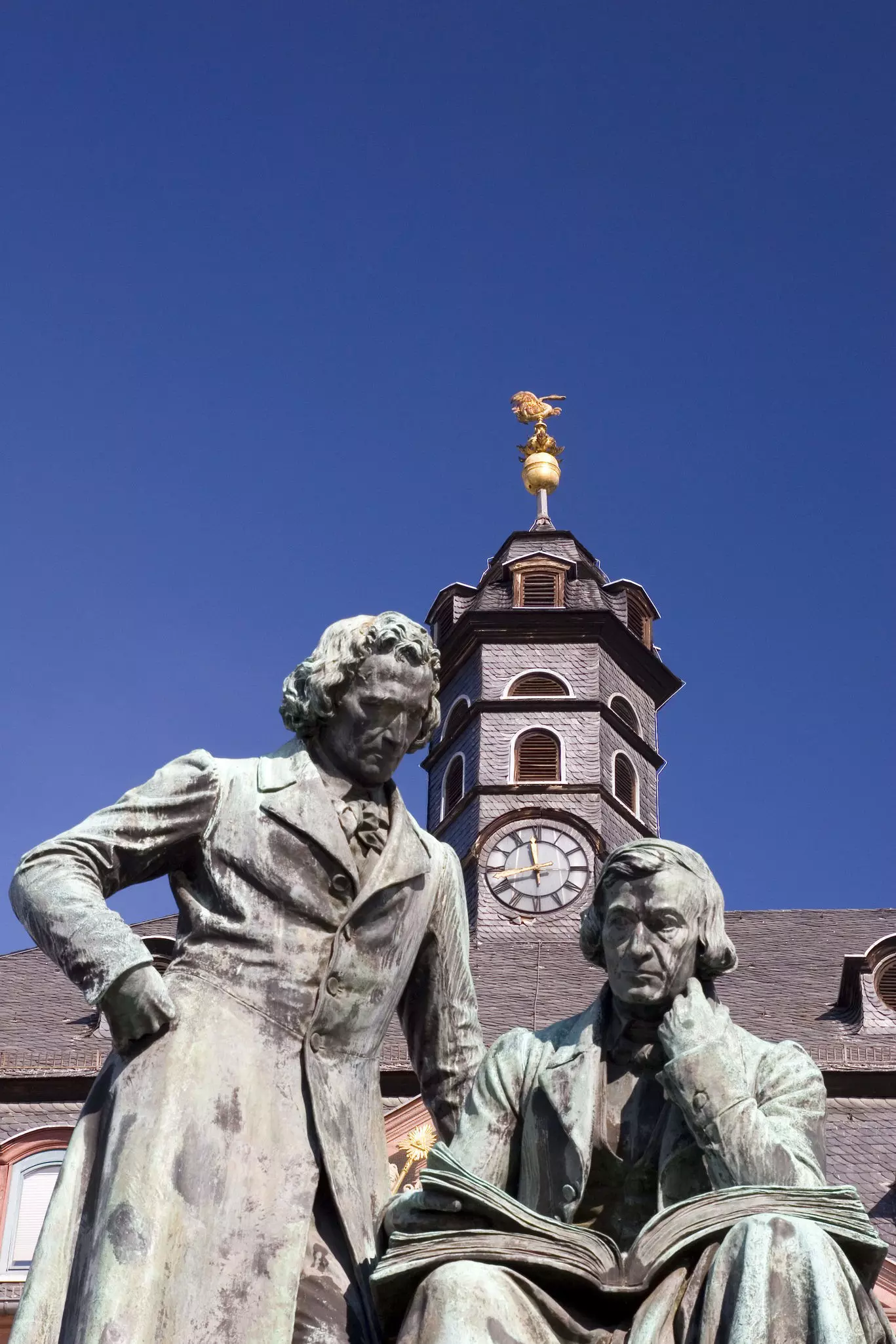 The author dressed in blue jeans and a plaid shirt, next to a faded barn wall