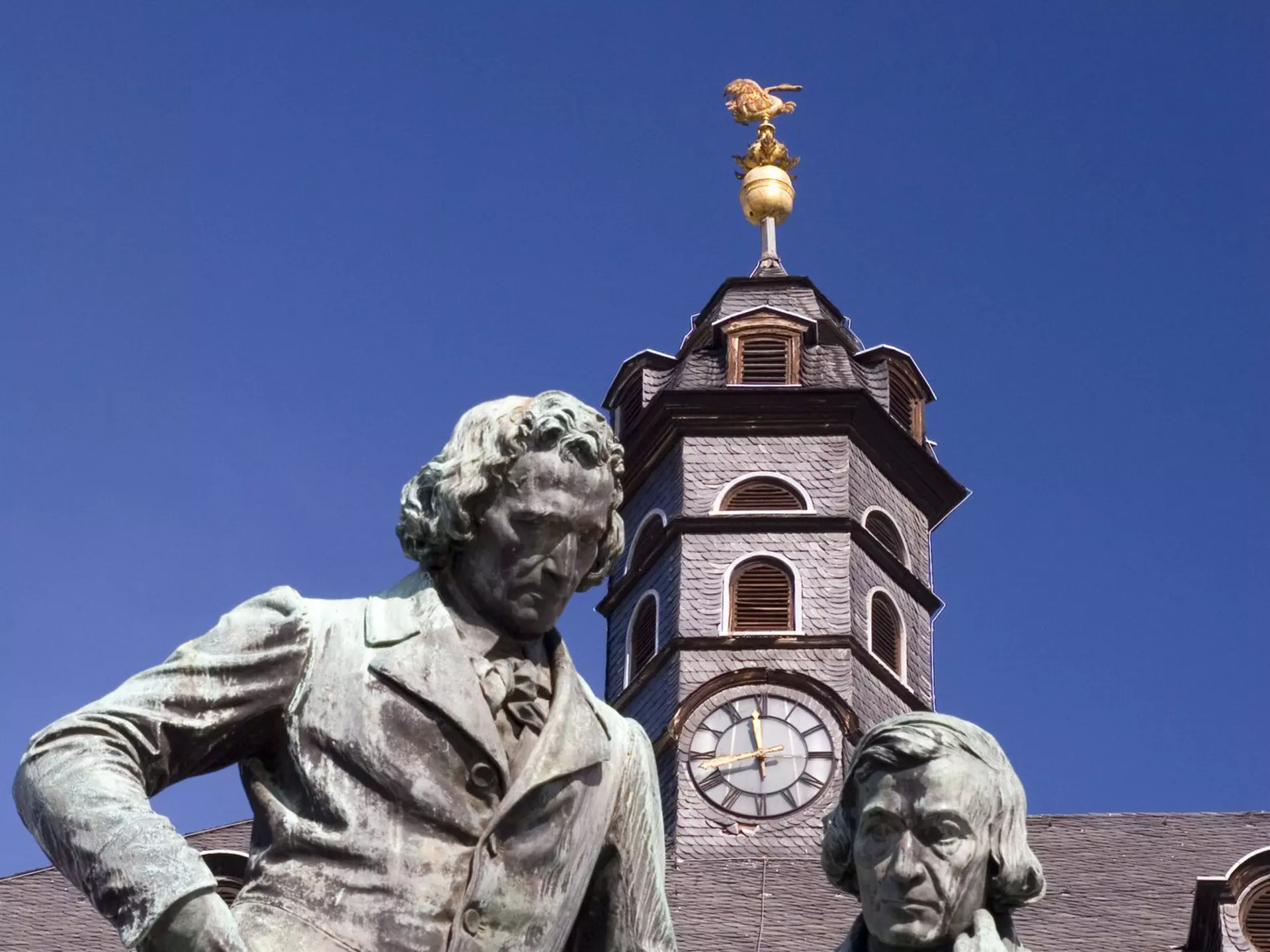 The author dressed in blue jeans and a plaid shirt, next to a faded barn wall