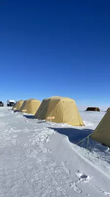 A row of yellow tents in the snow.
