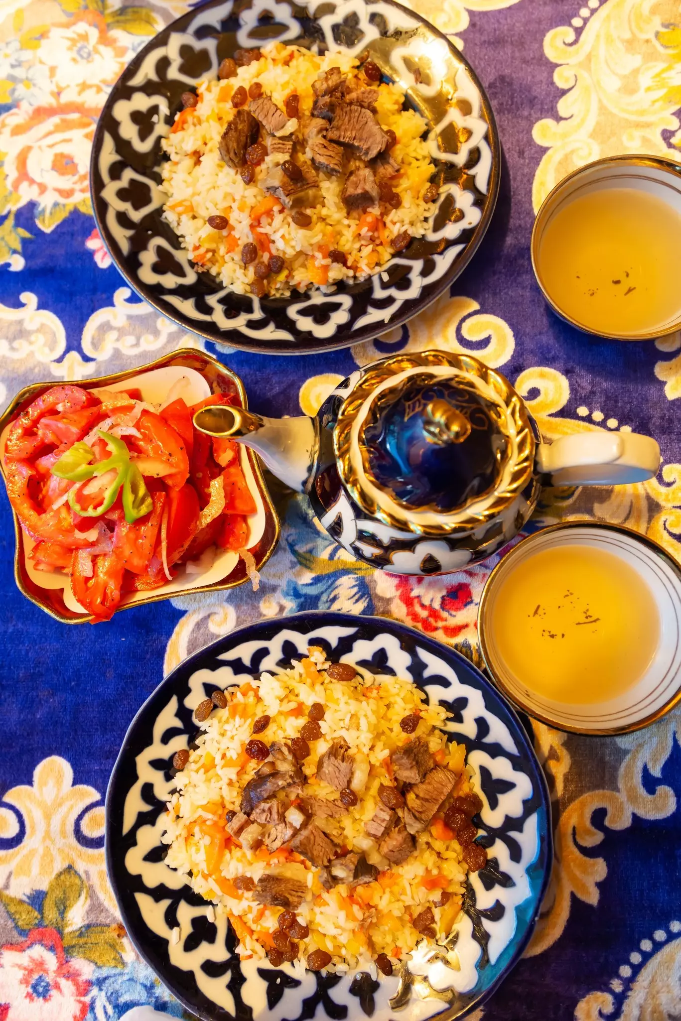 Traditional Uzbek plov, vegetable salad and green tea. Khiva, Uzbekistan.