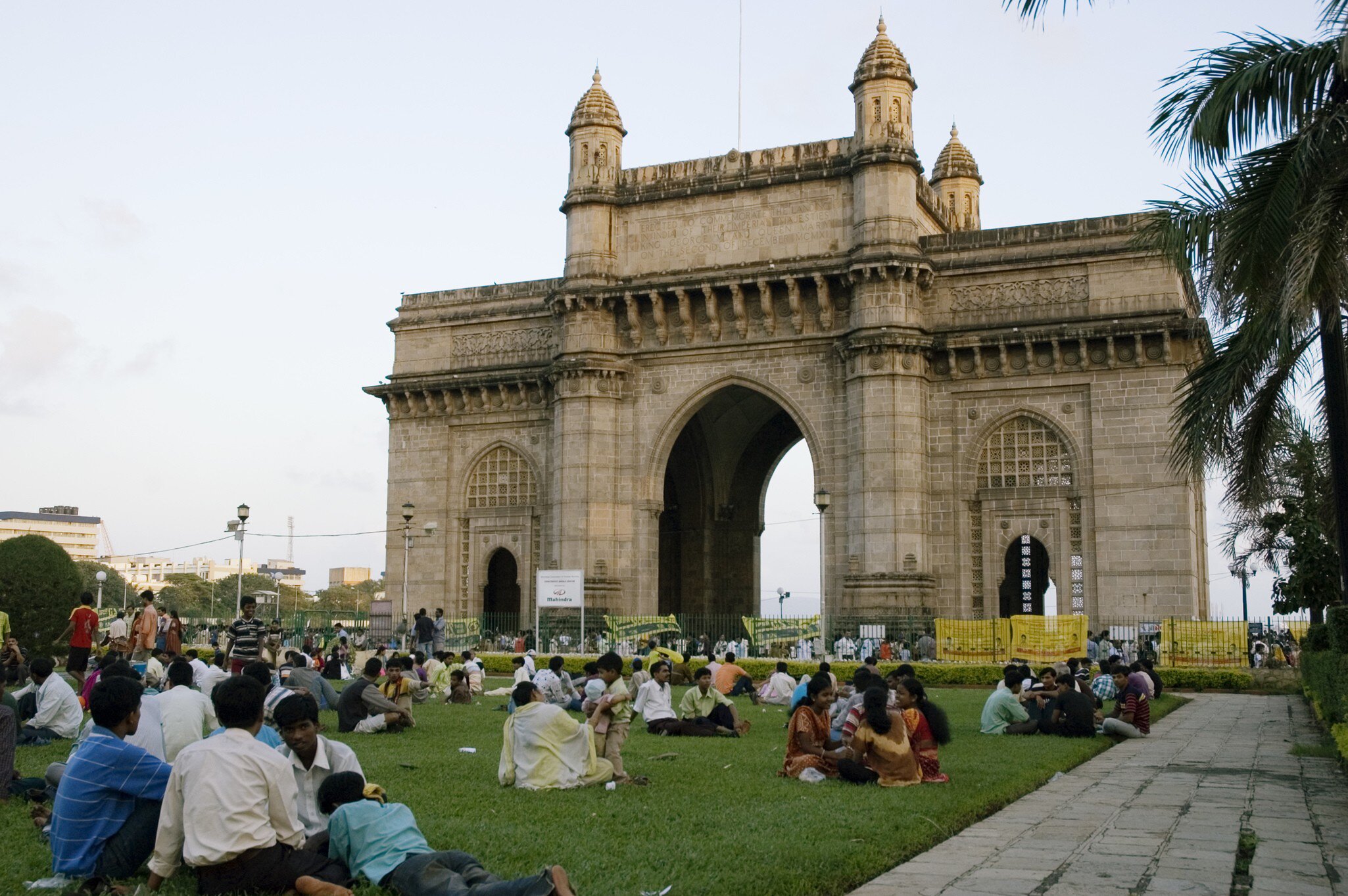 People sit on the lawn by the Gateway of India in Mumbai, India. 