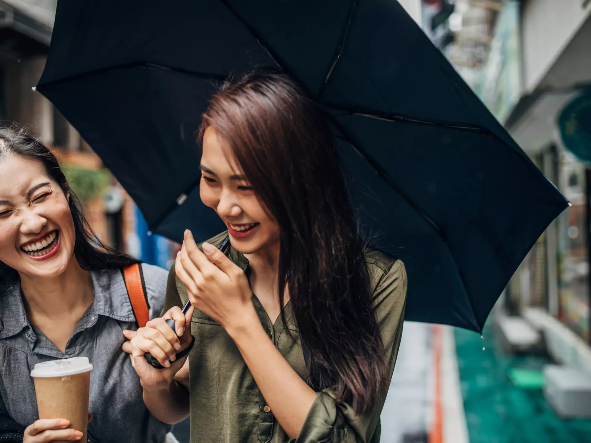 Two cheerful female friends walking on the street, holding umbrella and takeaway coffee, talking and laughing.
1156108102
CLEARED FOR DIGITAL USE ONLY -