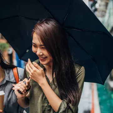 Two cheerful female friends walking on the street, holding umbrella and takeaway coffee, talking and laughing.
1156108102
CLEARED FOR DIGITAL USE ONLY -