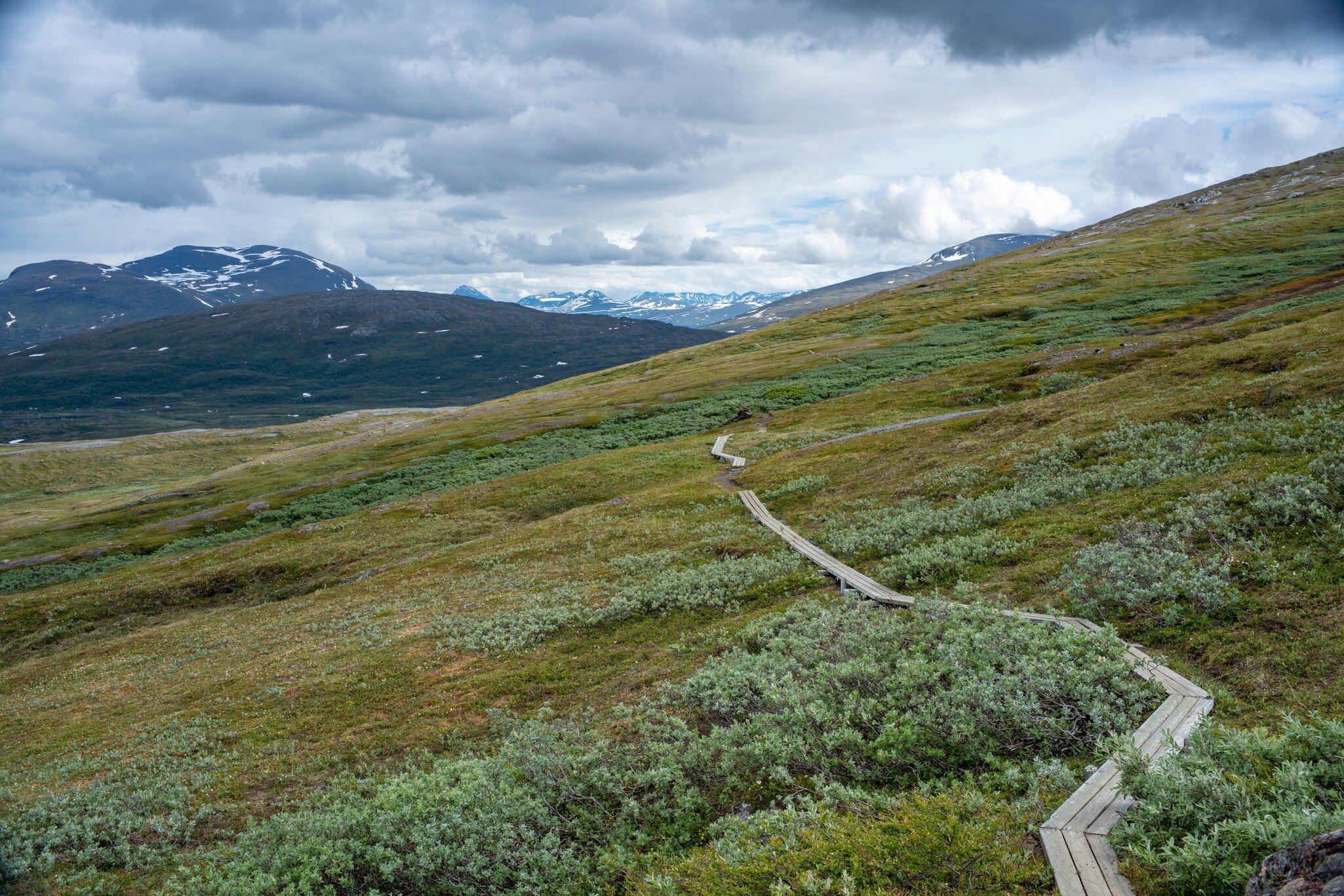 Panorama Mountain landscape and Wide Scenery in Padjelanta National Park with Wet Hiking Trail leading away from Camera during dramatic weather in the Summer in Northern Sweden, Lapland.; Shutterstock ID 1909032256;