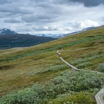Panorama Mountain landscape and Wide Scenery in Padjelanta National Park with Wet Hiking Trail leading away from Camera during dramatic weather in the Summer in Northern Sweden, Lapland.; Shutterstock ID 1909032256;
