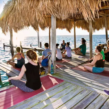 Backpackers doing yoga on the dock at Caye Caulker