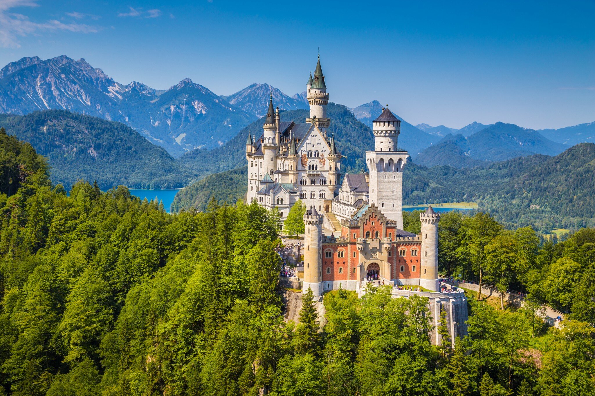 Fussen, Germany - August 7, 2015: Beautiful view of world-famous Neuschwanstein Castle, the nineteenth-century Romanesque Revival palace built for King Ludwig II on a rugged cliff, with scenic mountain landscape near Fussen, southwest Bavaria, Ger...