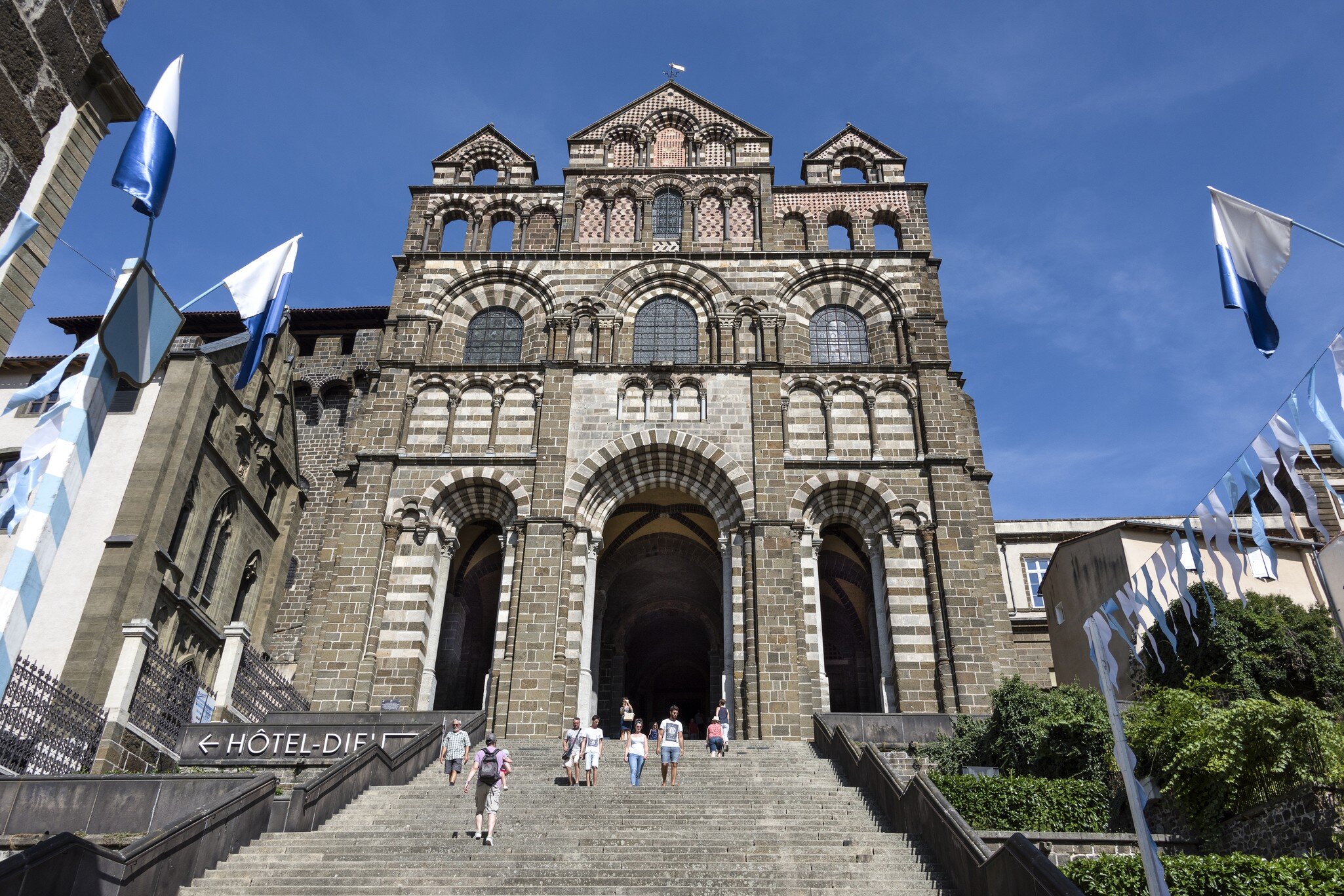 France, Auvergne Rhone Alpes, Haute Loire, Le Puy-en-Velay: People with main entrance facade of famous Cathedral of Our Lady of the Annunciation (Cathedral of Notre-Dame du Puy). August 07, 2017; Shutterstock ID 740800567;