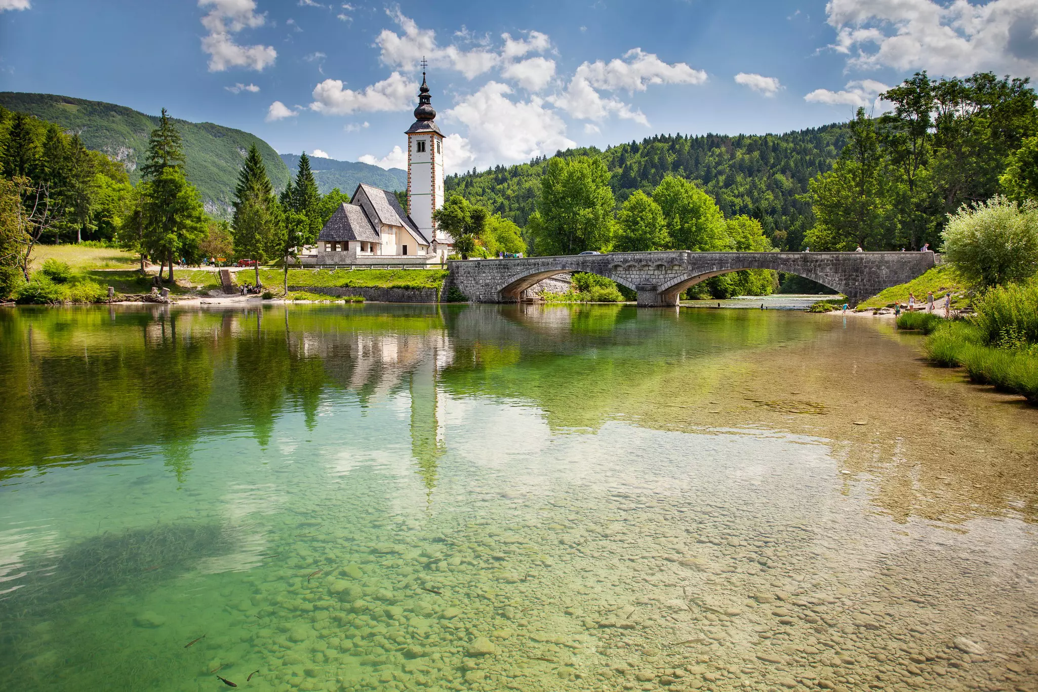 View of the Church of St. John the Baptist on the banks of the Sava river near Lake Bohinj in Slovenia.