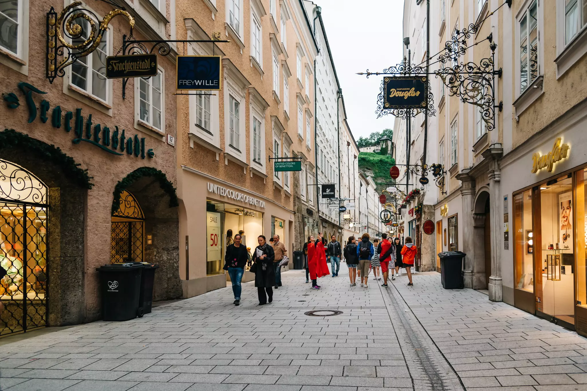 Scenic cityscape of historical city center of Salzburg with a small crowd of people walking