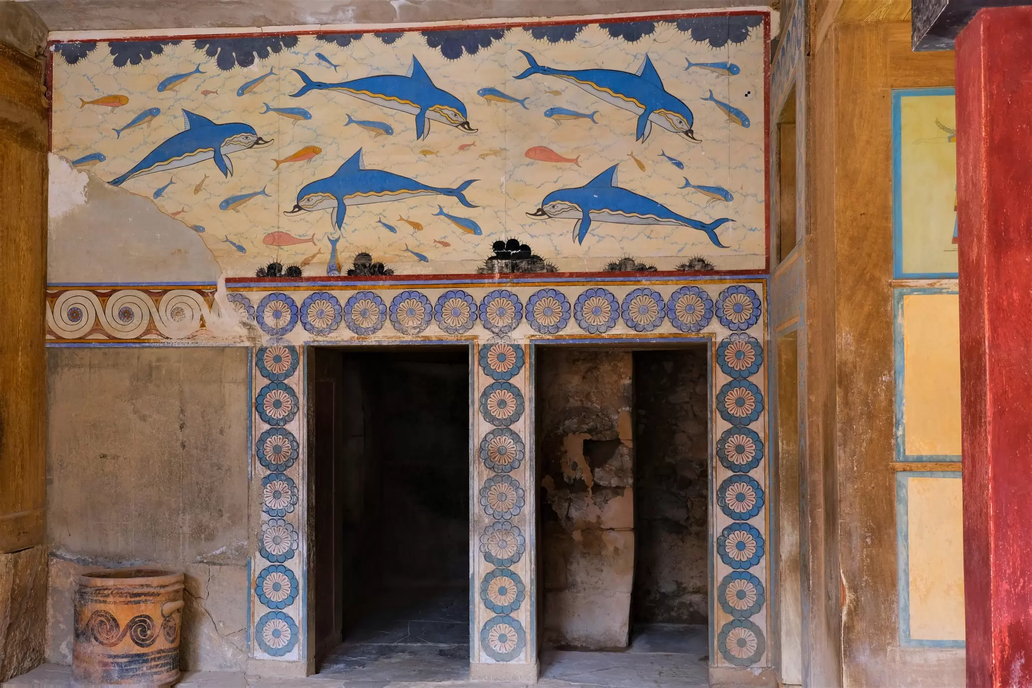Dolphin frescoes above a doorway in the Palace of Knossos. The frescoes depict blue dolphins and are highly detailed.