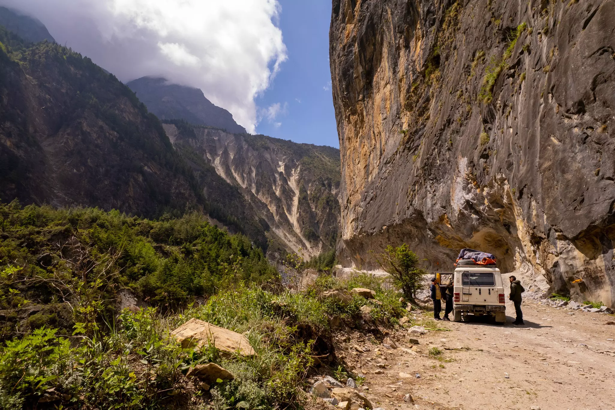 People stopping by their off-road vehicle during a drive through a mountain pass, Nepal