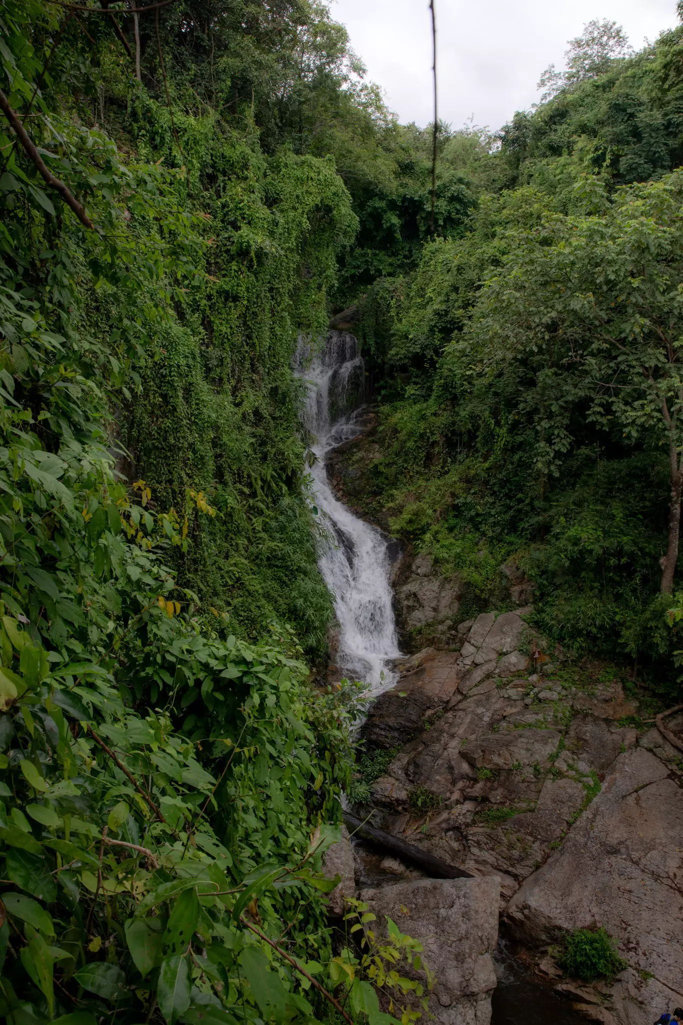 BIT 2025 Chiang Mai, Thailand August 2024. ..Huay Kaew Waterfall..Huay Kaew Waterfall is a natural attraction located near Chiang Mai city and is part of Doi Suthep National Park. The area is lush and rich in forest, with a steady flow of water throughout the year. However, the rocks can be quite slippery and abundant...Huay Kaew Waterfall is popular among Chiang Mai locals, including students and working professionals, who often visit during their free time due to its easy accessibility, pleasant weather, and peaceful environment, making it an ideal spot for relaxation. It also attracts both Thai and international tourists, partly because it is located near the revered Kru Ba Srivichai shrine, where many come to pay respects and make merit. for Lonely Planet...