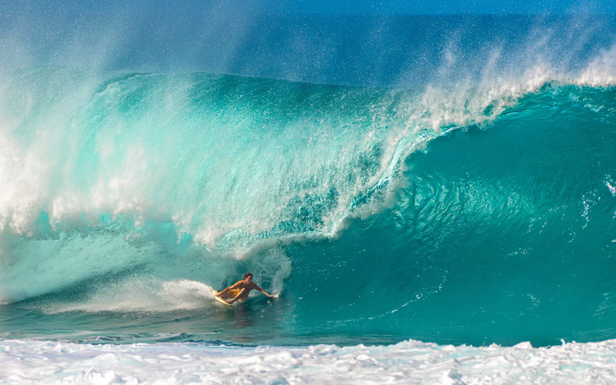 A surfer rides a huge wave, the Banzai Pipeline, a surf reef break located in Hawaiʻi