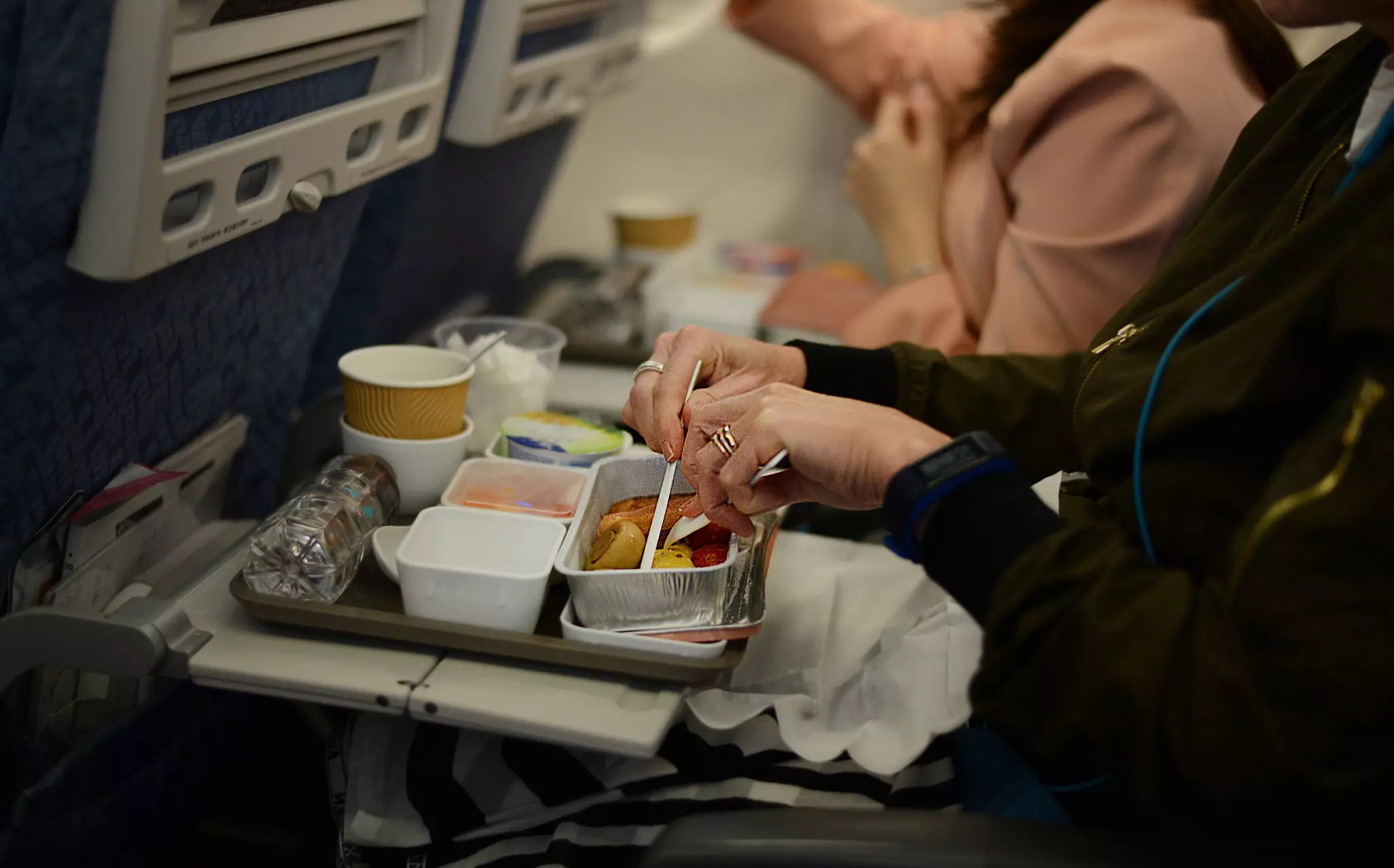 Passenger enjoying an in-flight breakfast on board an international flight in economy class.