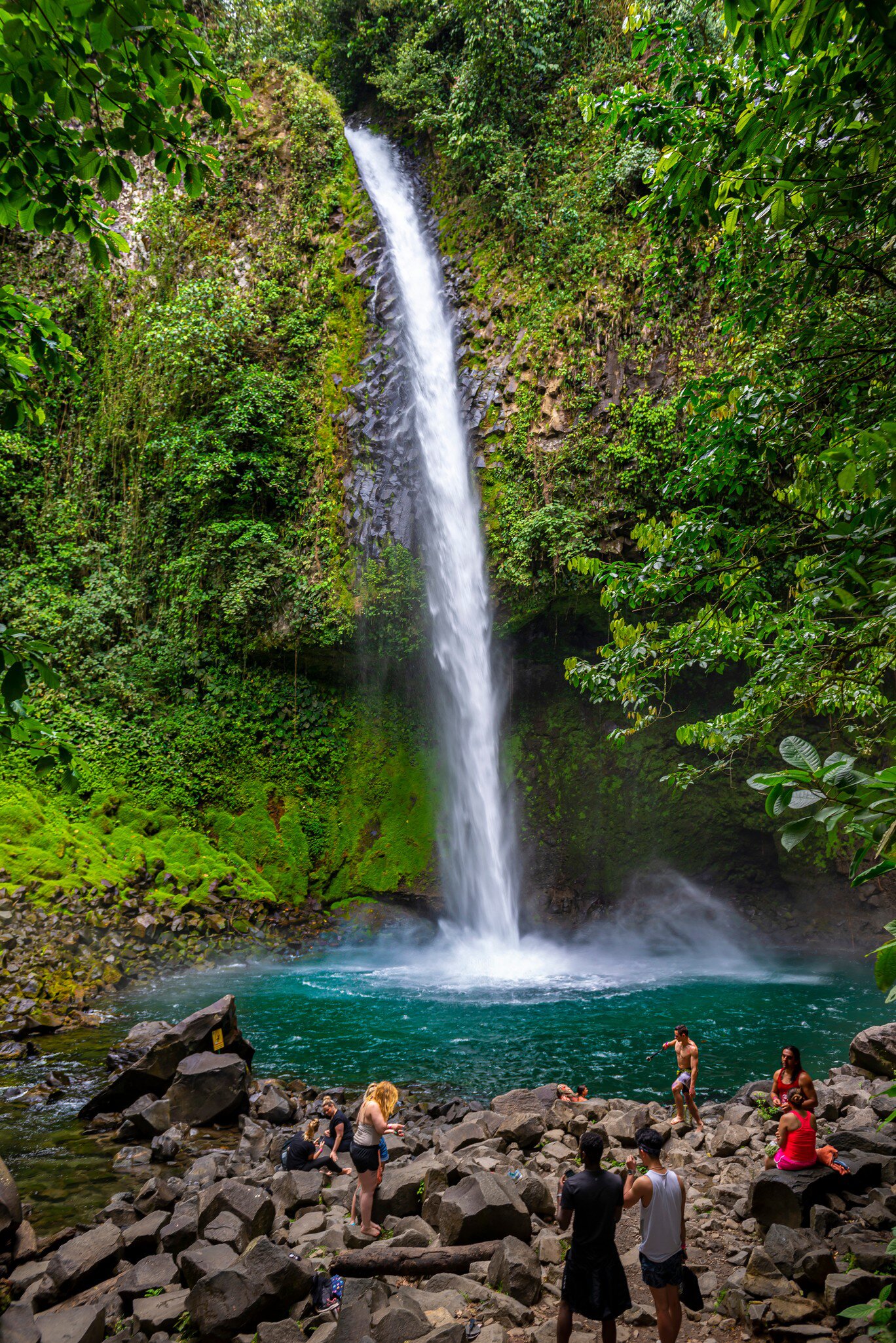 Tourists crowd around the base of the La Fortuna Waterfall, Costa Rica.