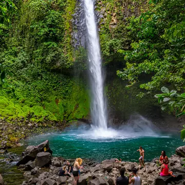 Tourists crowd around the base of the La Fortuna Waterfall, Costa Rica.
