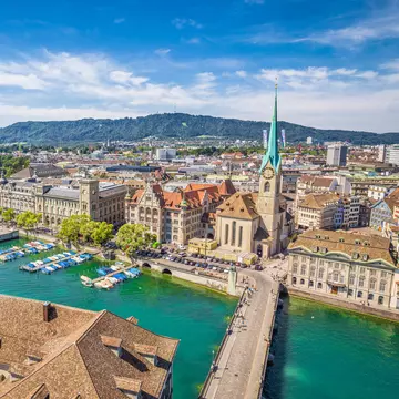 Aerial view of historic Zurich city center with famous Fraumunster Church and river Limmat at Lake Zurich from Grossmunster Church on a sunny day with clouds in summer, Canton of Zurich, Switzerland